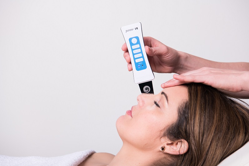 Client receiving a skin care treatment with a handheld device
